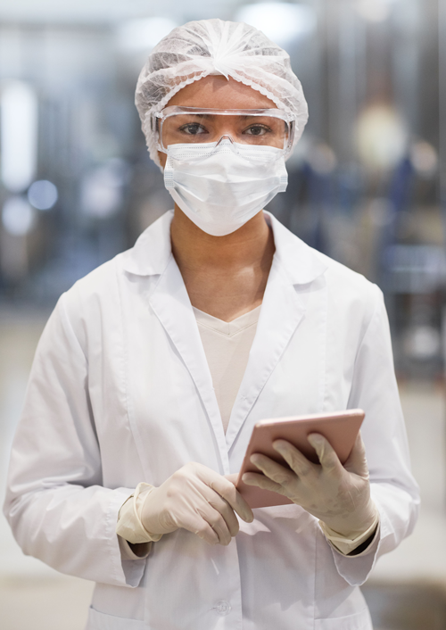 Young female worker looking up how to calculate OEE for manufacturing