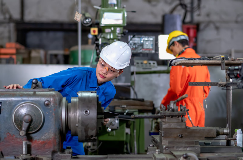 Female factory worker looking at part of the machine