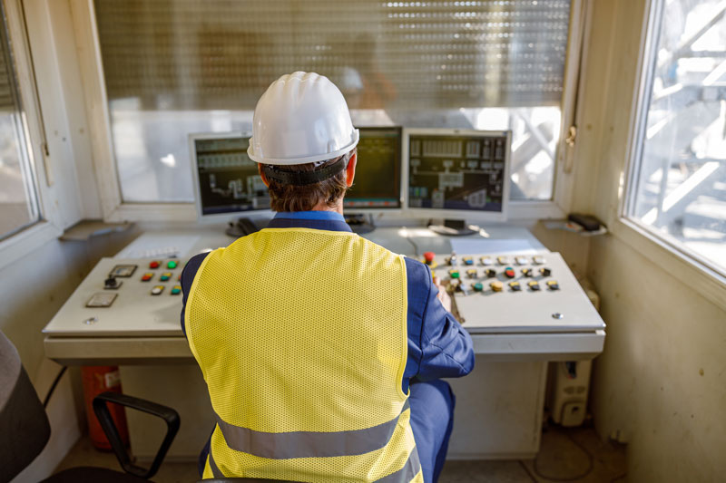 Male engineer using computers to review manufacturing KPIs