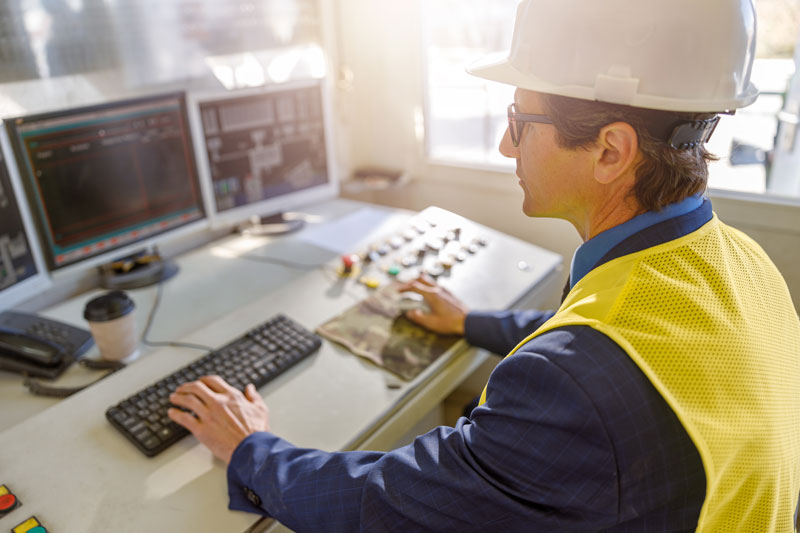 Male worker using computer to monitor manufacturing KPIs