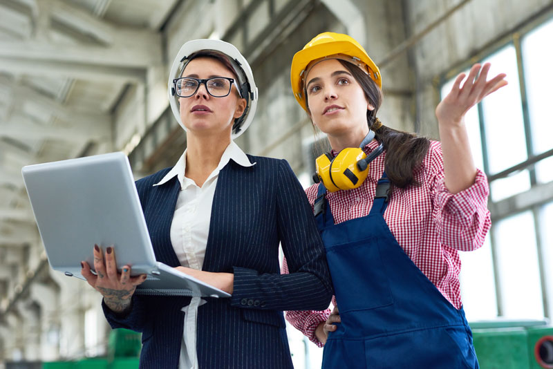 Two women reviewing manufacturing plant KPIs