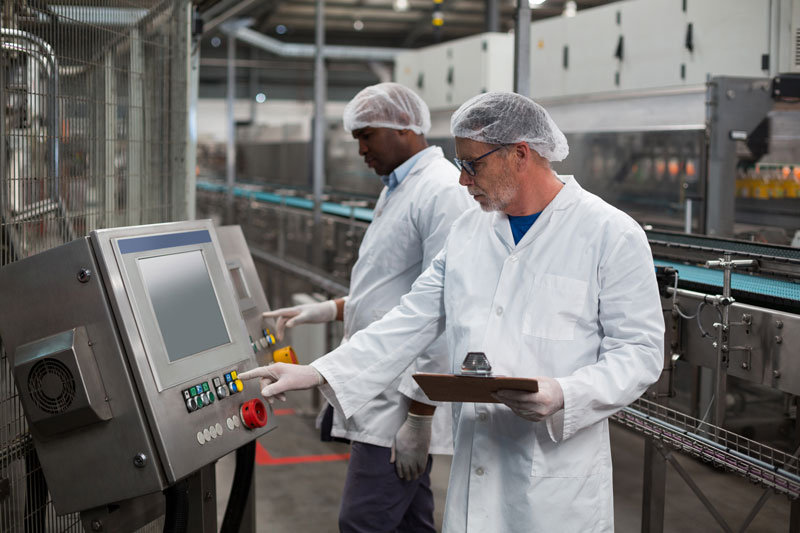 Two factory engineers operating machine for fully automated factory