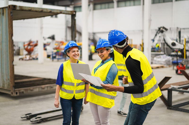 Multiracial engineers looking at OEE dashboard in manufacturing factory