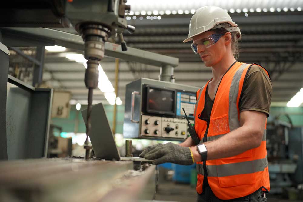 Lean manufacturing data on laptop being viewed by factory staff member