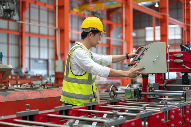 Asian male engineer calculating Mean Time To Repair of manufacturing machine