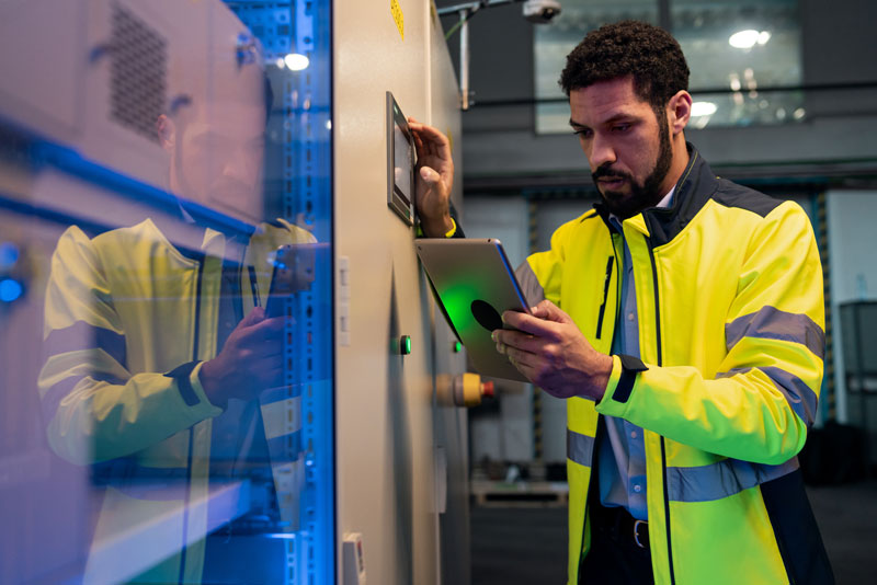 Machine data monitoring being conducted by young industrial worker