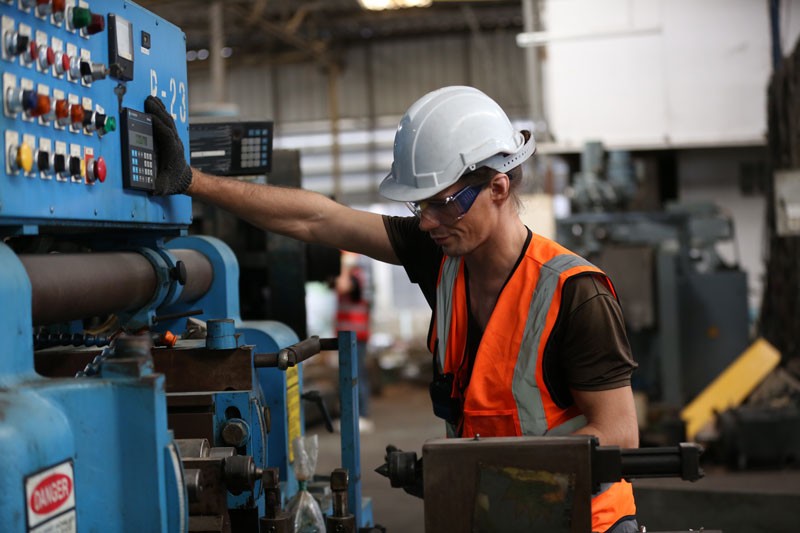 Industrial factory employee working on machine with OEE (Overall Equipment Effectiveness) software